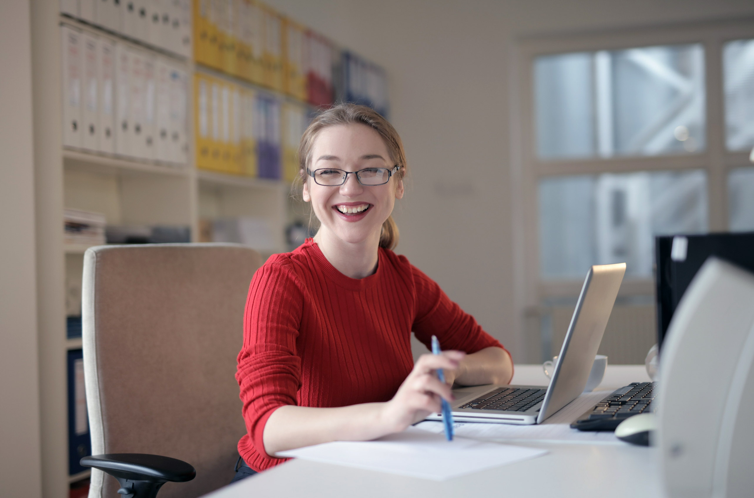 Woman smiling at a desk with laptop