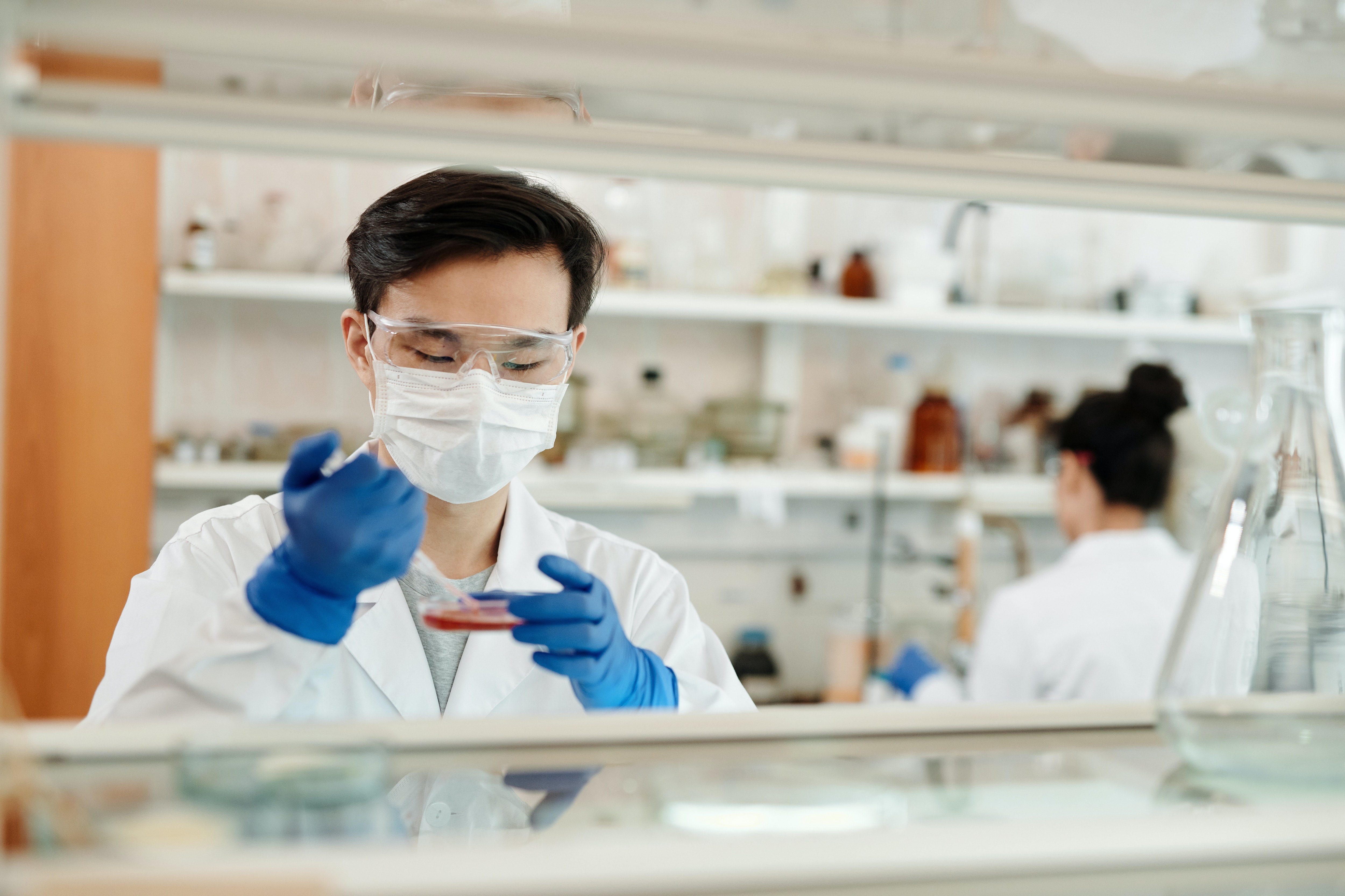 masked clinician with petri dish