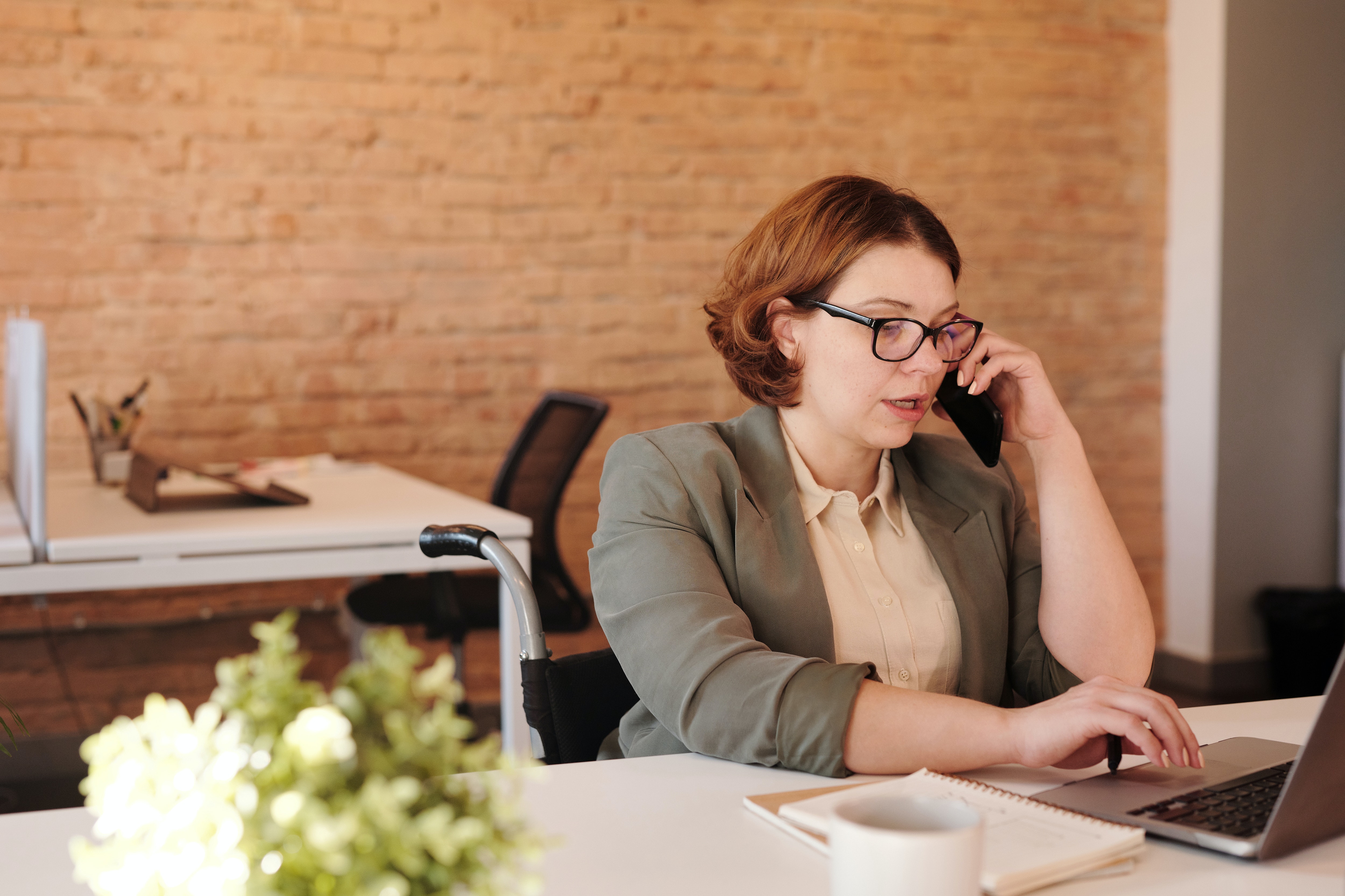 woman on the phone, working on a laptop